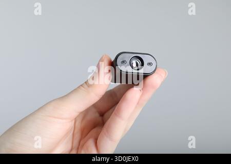 Frau mit versteckter Spionageschiene auf hellgrauem Hintergrund, Nahaufnahme Stockfoto
