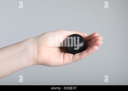 Frau mit versteckter Spionageschiene auf hellgrauem Hintergrund, Nahaufnahme Stockfoto