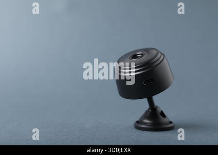 Versteckte Spionagekamera auf grauem Hintergrund, Nahaufnahme. Leerzeichen für Text Stockfoto