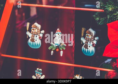 Weihnachtsdekoration in einem Schaufenster – niedliche Schneemänner und Eulenfiguren werden in einem Weihnachtsgeschäft ausgestellt. Festliche Winterferienatmosphäre Stockfoto