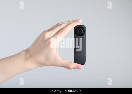 Frau mit versteckter Spionageschiene auf hellgrauem Hintergrund, Nahaufnahme Stockfoto