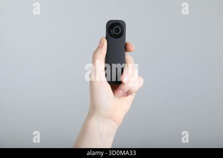 Frau mit versteckter Spionageschiene auf hellgrauem Hintergrund, Nahaufnahme Stockfoto