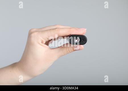 Frau mit versteckter Spionageschiene auf hellgrauem Hintergrund, Nahaufnahme Stockfoto