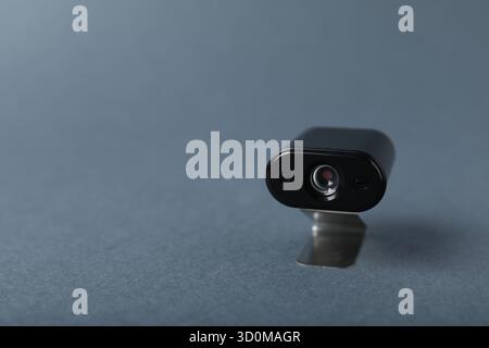 Versteckte Spionagekamera auf grauem Hintergrund, Nahaufnahme. Leerzeichen für Text Stockfoto