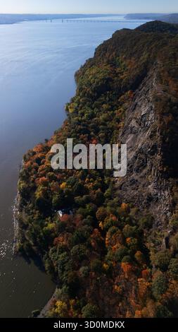 Aus der Vogelperspektive auf den Hudson River, der neben den dramatischen Klippen und dem farbenfrohen Herbstlaub der Palisades fließt, Nyack, New York, USA. Stockfoto