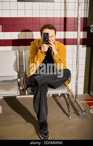 Junger Mann, der ein Foto in einem modernen Innenbereich macht Stockfoto