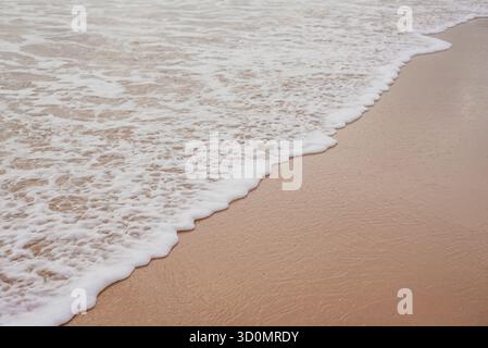 Sanfte Ozeanwellen, die über Sand am Karon Beach, Phuket, Thailand Stockfoto
