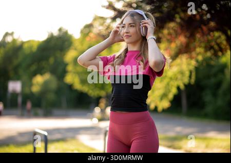 Frau genießt Musik im Freien in Sportbekleidung Stockfoto