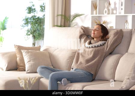 Frau, die im Winter auf einer Couch sitzt Stockfoto