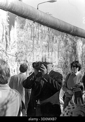 DEU, Deutschland, Berlin, 18.03.1990: Unweit von Checkpoint Charlie filmt US-Botschafter Vernon Walters ein Video, in dem die Mauer von Spechten gemalt wird. HF [automatisierte Übersetzung] Stockfoto
