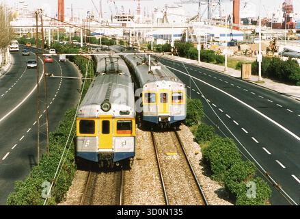 P, Portugal, Lissabon, 20.03.1993: Zwei ältere Triebwagen von Alstom für die Lissabonner Vorortbahn der staatlichen Eisenbahngesellschaft CP Urbanos de Lisboa, die hauptsächlich von Pendlern genutzt wird, treffen auf der Strecke am Ufer des Tejo aufeinander. [Automatisierte Übersetzung] Stockfoto
