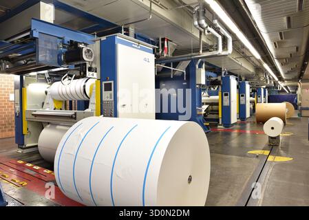 Papierrollen und Offsetdruck Maschinen in einer großen Druckerei für die Produktion von Zeitungen & Zeitschriften Stockfoto