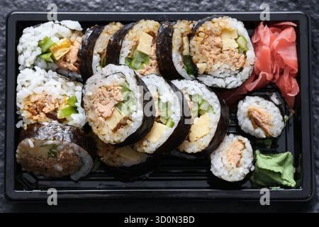 Sushi-Brötchen zum Mitnehmen aus der Nähe. Japanische Küche in Plastikbehältern. Verzehrfertige Mahlzeit. Asiatisches Konzept für die Lieferung von Lebensmitteln. Stockfoto