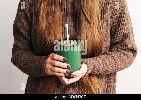 Frau mit Yerba Mate Cup. Traditionelles südamerikanisches Trinkritual. Warmer, gemütlicher Lifestyle-Moment. Natürliches Koffeingetränk-Konzept. Stockfoto