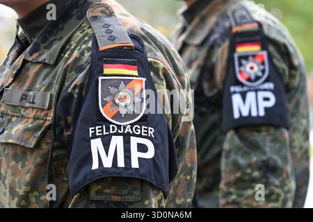 Beelitz, Deutschland. Oktober 2025. Armbänder mit der Aufschrift „Feldjäger MP“ sind auf den Uniformen der Bundeswehr-Soldaten bei der feierlichen Vereidigung im Stadtpark zu sehen. Quelle: Jens Kalaene/dpa/Alamy Live News Stockfoto