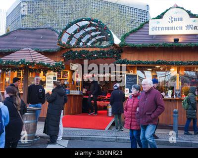 Berlin, Deutschland - 01. Januar 2024: Weihnachtsmarkt mit festlichen Dekorationen und geschäftigen Einkäufern, die die Atmosphäre genießen. Stockfoto