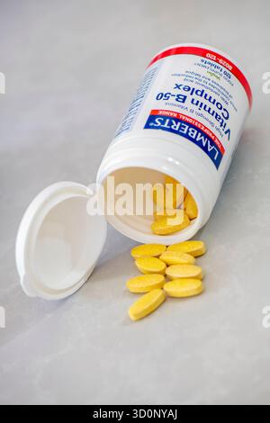 Vitamin B-50 Komplexe Nahrungsergänzungsmittel sind Plastikröhrchen mit Pillen, Tabletten und Kapseln, die aus der Verpackung auf eine weiße Oberfläche gelangen. Stockfoto