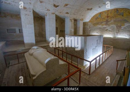 Luxor, Ägypten - 18. Januar 2025: Zwei Sarkophage ruhen im Grab von Merenptah KV8, umgeben von verblassten Wandgemälden und Hieroglyphen. Die Kammer reflektiert Stockfoto