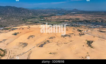 Weitläufige Sanddünen von Phan Rang, Vietnam – aus der Vogelperspektive auf die Wüstenlandschaft und die umliegenden Hügel Stockfoto
