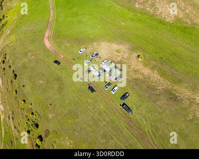Koy Tash, Kirgisistan - 13. Mai 2024: Drohnenansicht eines Campingplatzes mit mehreren Autos und Zelten auf einem grasbewachsenen Hügel in der Nähe von Bischkek Stockfoto