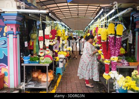 Kuala Lumpur. Malaysia. August 2025. Farbenfrohe Blumengirlanden werden an einem Kiosk am Straßenrand auf dem geschäftigen Indian Quarter Market ausgestellt Stockfoto