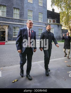 London, Großbritannien. Oktober 2025. Wolodymyr Zelenskyy, Präsident der Ukraine, und Sir Keir Starmer, Premierminister des Vereinigten Königreichs, gehen von der Downing Street 10 zum Außenministerium, wo sie von ukrainischen Kindern mit Fahnen begrüßt werden. Starmer wird Zelenskyy und andere führende Politiker zu den Treffen der "Koalition der Willigen" im Auswärtigen Amt begrüßen. Quelle: Imageplotter/Alamy Live News Stockfoto