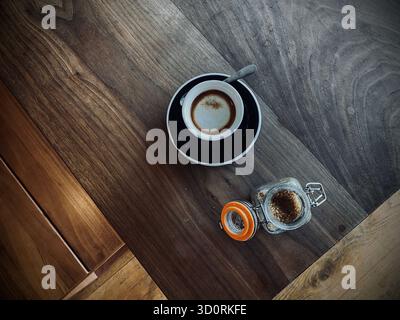 Macchiato-Kaffee auf der Bank mit Zucker in einem Topf, leerer Tisch West Sussex, England Stockfoto