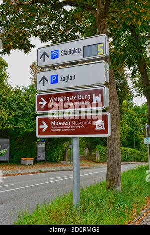 Mehrere Schilder weisen auf das längste Schloss und Museum der Welt in Burghausen, Deutschland Stockfoto