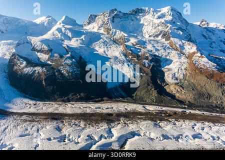 Breithorn von Zermatt vom Gornergrat über den Gorner-Gletscher. Eine zentrale Moräne bedeckt die Mitte. Der Gletscher weist viele Spalten auf. Stockfoto