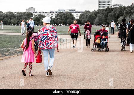 Menschen mit unterschiedlichem Hintergrund wandern und entspannen im Hyde Park, London an einem sonnigen Tag. Stockfoto