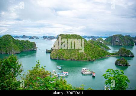 Panoramablick auf die Halong-Bucht in Nordvietnam mit Kalksteinkarstinseln, die über das türkisfarbene Meer in der zum UNESCO-Weltkulturerbe gehörenden Gegend verstreut sind. Stockfoto