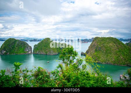 Panoramablick auf die Halong-Bucht in Nordvietnam mit Kalksteinkarstinseln, die über das türkisfarbene Meer in der zum UNESCO-Weltkulturerbe gehörenden Gegend verstreut sind. Stockfoto