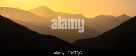 Silhouettengebirge in Juf, Schweiz, bei Sonnenuntergang mit goldenem Himmel. Stockfoto