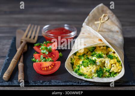 Hausgemachte Burrito-Wraps mit Rührei-Omelett und Mikrogrün für gesundes Frühstück auf Holzbrett, Nahaufnahme Stockfoto