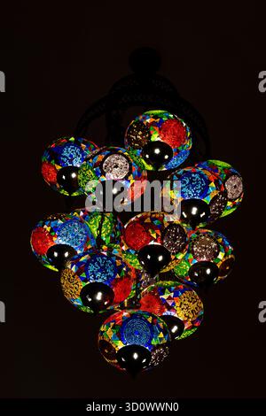 Traditionelle türkische Lampen hängen nachts an der Decke. Exquisite bunte Mosaikglaslampen, Nahaufnahme, Truthahn Stockfoto