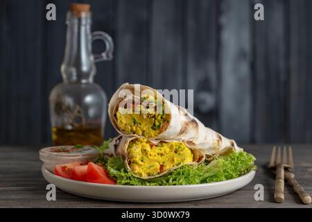 Burrito-Wraps mit Eieromelette, Gemüse und Kräutern in Pitabrot, Nahaufnahme Stockfoto