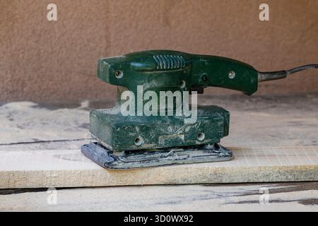 Arbeiter schleifen Holzbretter mit einem Schwingschleifer in einer Werkstatt, Nahaufnahme. Elektrowerkzeug Stockfoto