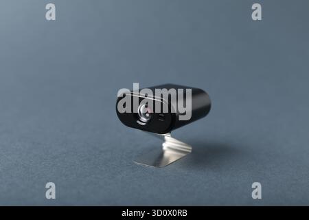 Versteckte Spionagekamera auf grauem Hintergrund, Nahaufnahme Stockfoto