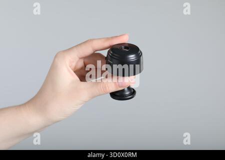 Frau mit versteckter Spionageschiene auf hellgrauem Hintergrund, Nahaufnahme Stockfoto