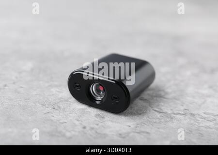 Moderne, versteckte Spionageskamera auf hellgrauem Tisch, Nahaufnahme Stockfoto