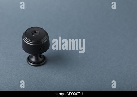 Versteckte Spionagekamera auf grauem Hintergrund, Nahaufnahme. Leerzeichen für Text Stockfoto