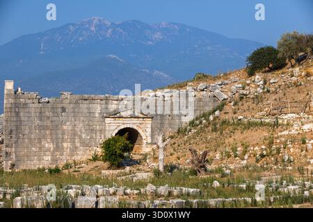 Eingang des römischen Theaters, Patara antike Stadt. Ein historisches Amphitheater aus Stein Ruinen verwitterter Mauern befindet sich in einer sonnendurchfluteten Landschaft. Türkei Stockfoto