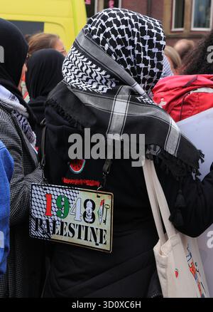 Frau mit einem Keffiyeh und einem Palästinenserzeichen von 1948 während einer palästinensischen Solidaritätsdemonstration in Amsterdam am 5. Oktober 2025 Stockfoto