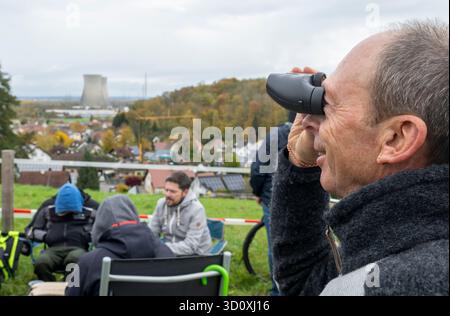 Gundremmingen, Deutschland. Oktober 2025. Johann Schorer schaut sich das Kernkraftwerk mit einem Fernglas an. Die beiden Kühltürme des stillgelegten Kernkraftwerks sollen gesprengt werden. Quelle: Stefan Puchner/dpa/Alamy Live News Stockfoto