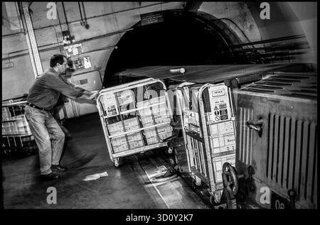 Postarbeiter, der Postsäcke in den U-Bahn-Zug unter Mount Pleasant lädt, London, Großbritannien. 1990er Jahre Stockfoto