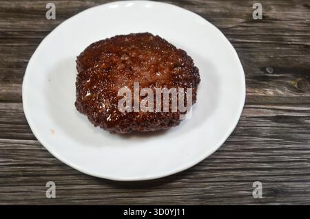Gekochtes Hamburger-Patty aus gemahlenem Rindfleisch, eine Hackfleischscheibe, typischerweise gewürzt, aus gemahlenem Rindfleisch gebildet, in flachem Öl gegrillt, gekochtes Fleisch Stockfoto