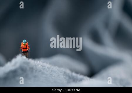 Eine Bergsteiger Figur auf flauschigem Fleece-Material, das wie eine schneebedeckte Bergoberfläche aussieht Stockfoto