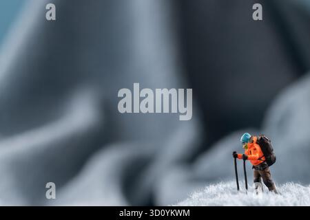 Eine Bergsteiger Figur auf flauschigem Fleece-Material, das wie eine schneebedeckte Bergoberfläche aussieht Stockfoto