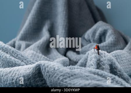 Eine Bergsteiger Figur auf flauschigem Fleece-Material, das wie eine schneebedeckte Bergoberfläche aussieht Stockfoto