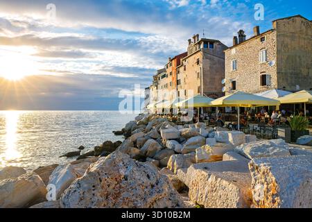 In Rovinj, Kroatien, einem malerischen Fischerhafen an der Westküste der istrischen Halbinsel, finden Sie Cafés am Meer in der Abenddämmerung entlang der Adria. Stockfoto